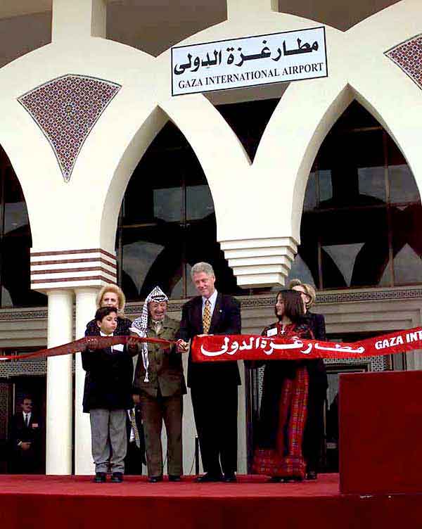 Yasser Arafat and Bill Clinton cut the ribbon at Gaza International Airport in 1998, Suha Arafat behind them
