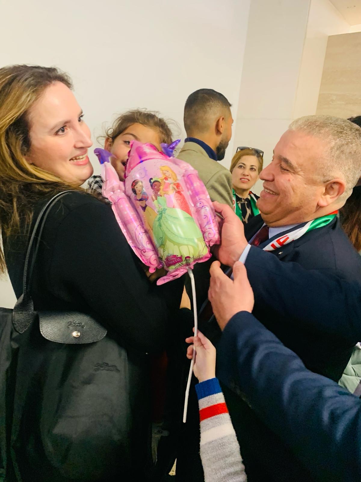 Zahwa Arafat carries Silla, a wounded girl evacuated from Gaza, on her arrival in Malta